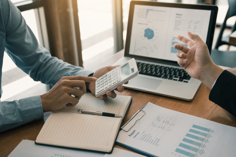 Two business partnership coworkers analysis strategy with discussing a financial planning graph and company budget during a budget meeting in office room.